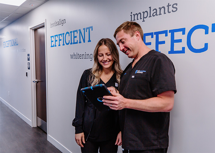 Dr. Bill Keith and hygienist looking at a tablet keith + associates dentistry in Mission, KS.