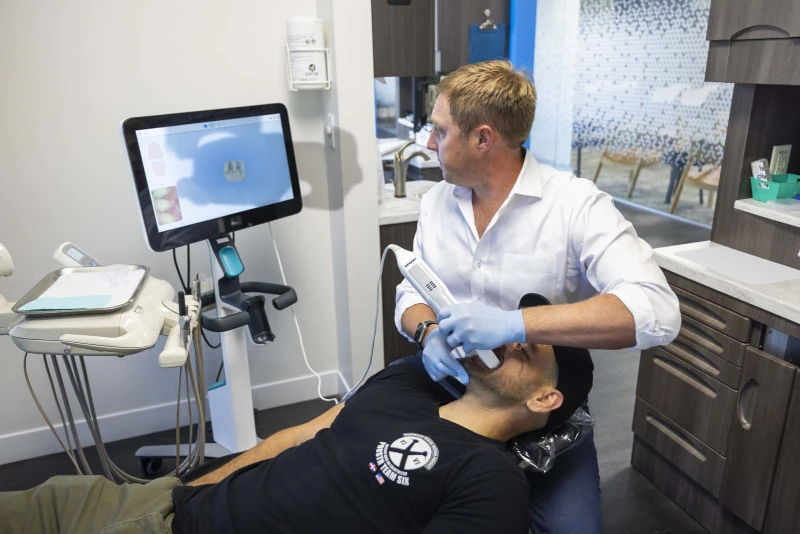 Dr. Bill Keith using an intraoral camera on a dental patient.