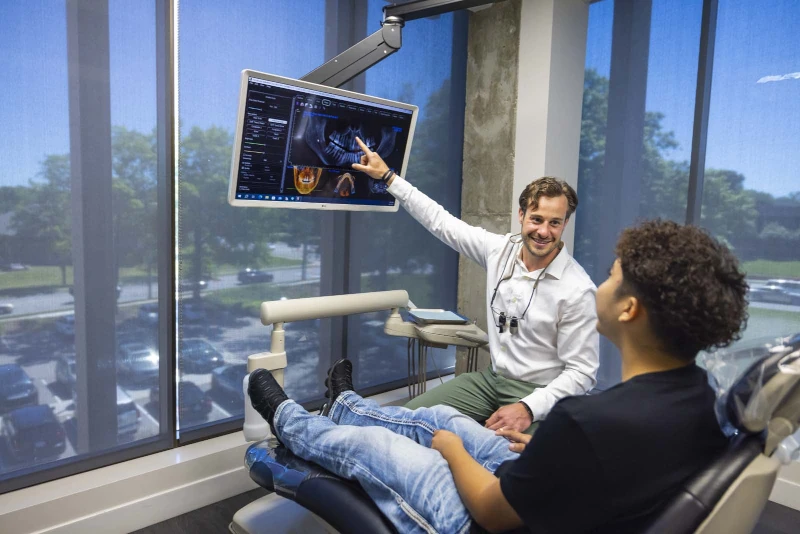 Dr. Shawn Custer talking to a patient and pointing at an x-ray on a screen.
